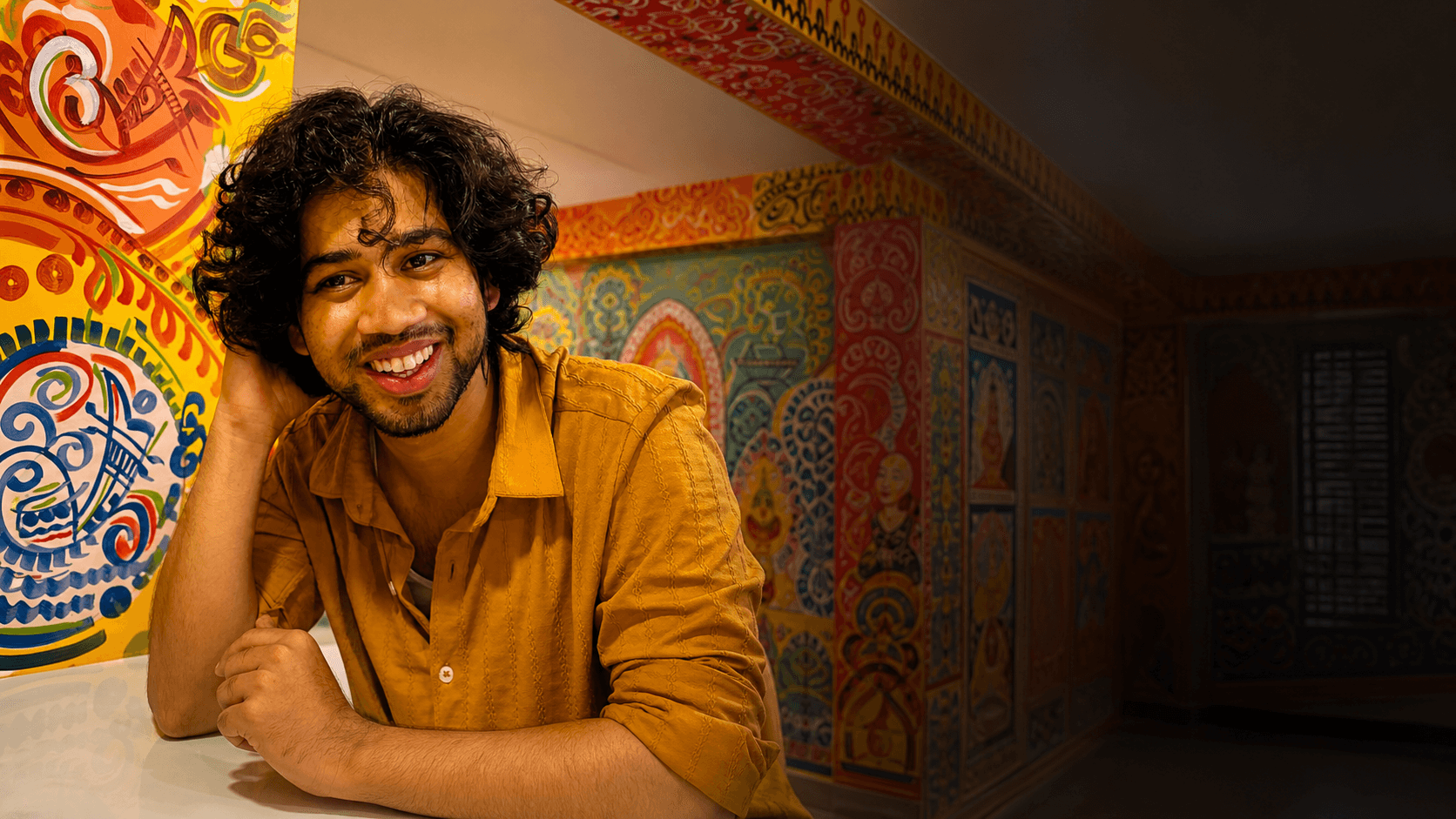 Ashraful Momin smiling in a colorful creative studio
